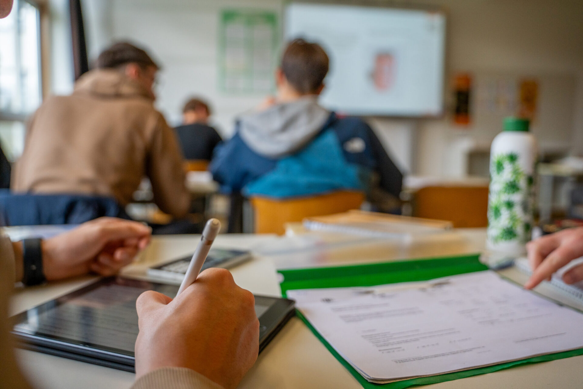 Schüler am Tisch mit Tablet und Buch