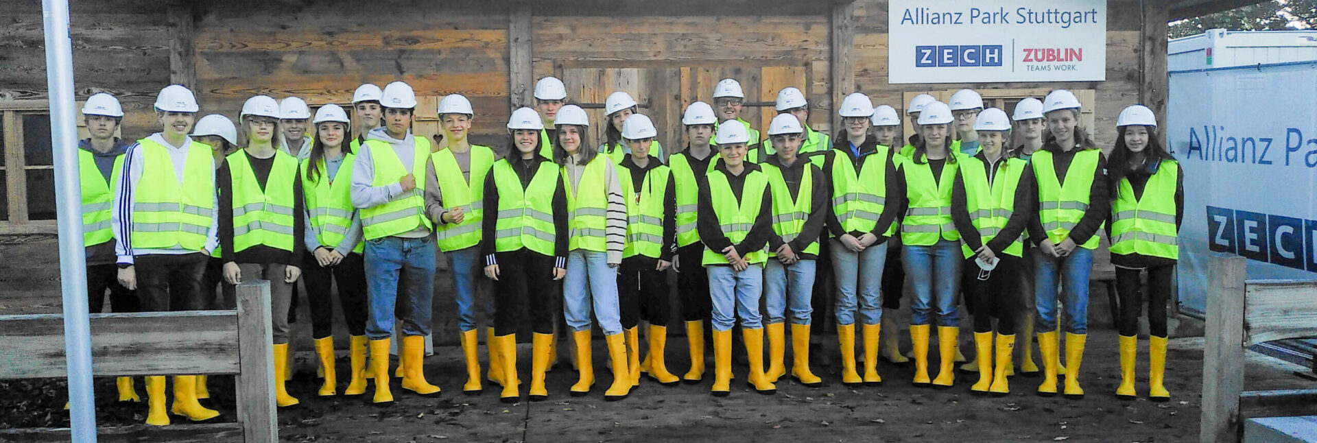 Schülergruppe am Projekttag Arbeitsweltmit Warnwesten und Helm